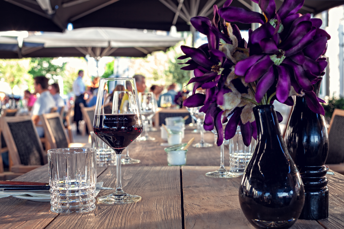 Außenbereich Tisch mit Rotwein und lila Pflanze