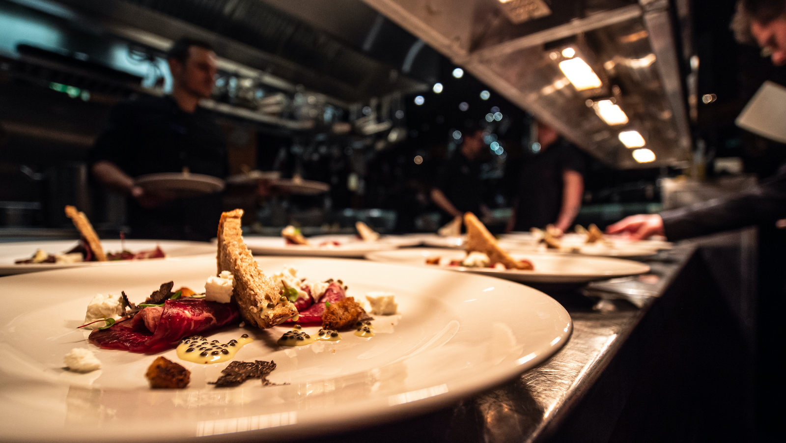 mehrere Speisen werden in der Küche vorbereitet im Steakhouse, Restaurant Rocca 800°C im Düsseldorfer Medienhafen